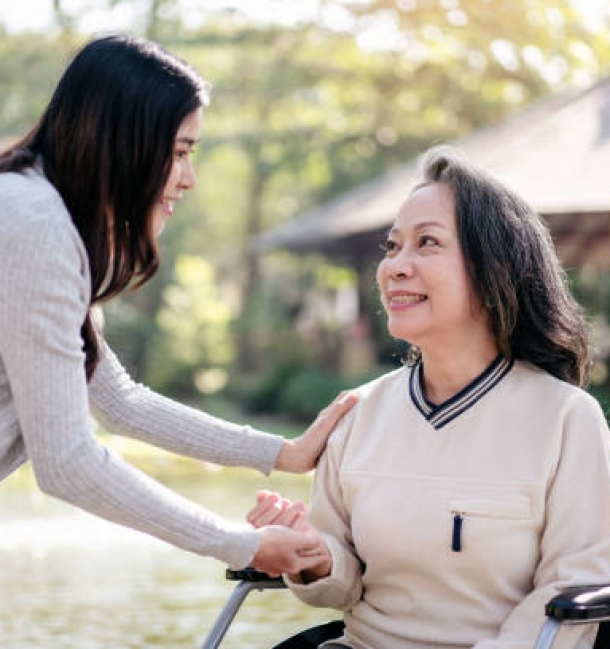 Happy family, Elderly grandmother in wheelchair with daughter smiling enjoying at the garden in the morning.